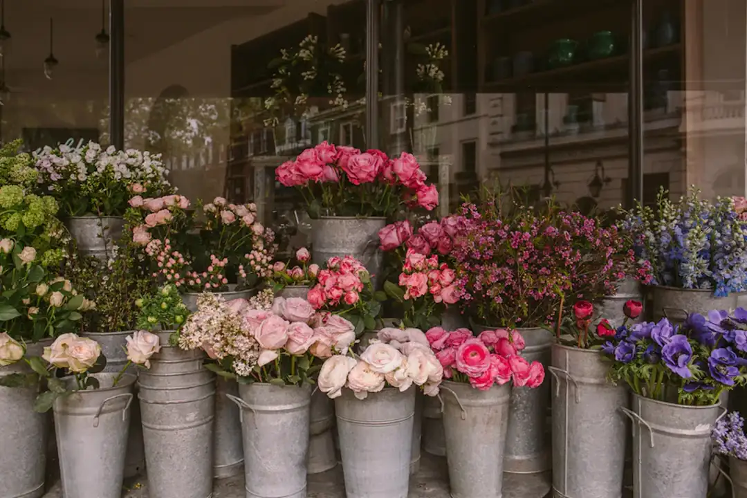 Secchi pieni di fiori freschi davanti alla bottega