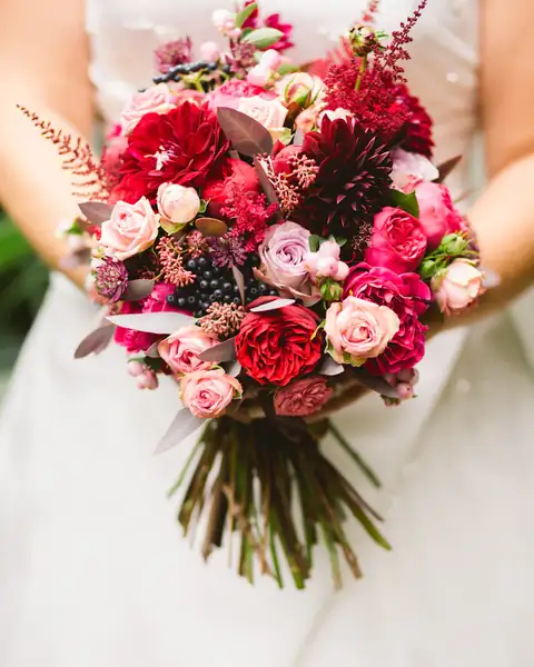 Sposa con bouquet di rose rosse